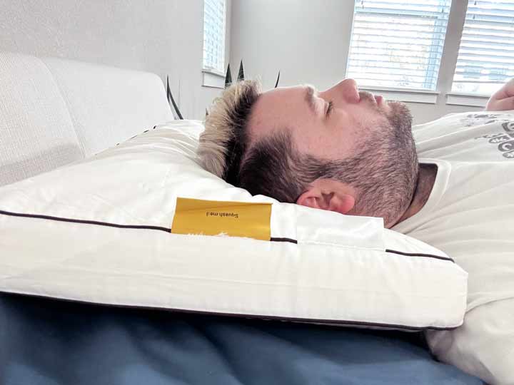 A man rests on his back using the Nolah Cooling Foam pillow.