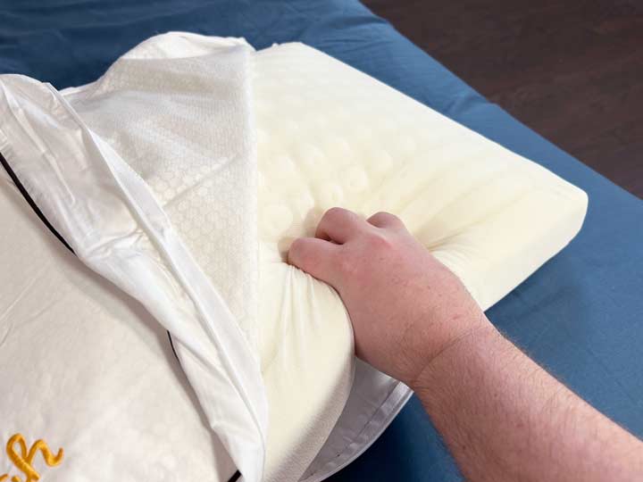 A hand squeezes the foam that is used in the Nolah Cooling Foam pillow.