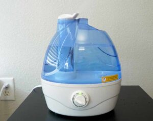 An image of the AquaOasis Cool Mist humidifier on a bedside table.