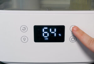 A close up image of the screen on the Levoit Smart humidifier. It shows that the room is at 64% humidity.
