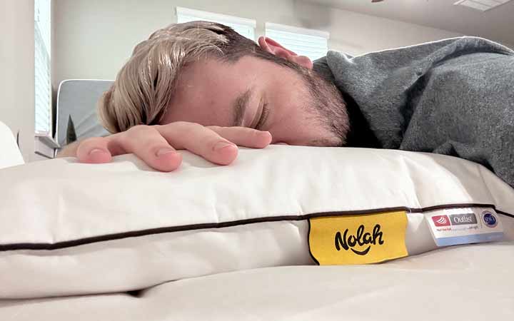 An image of a man sleeping on his stomach while using the Nolah Airfiber Pillow.