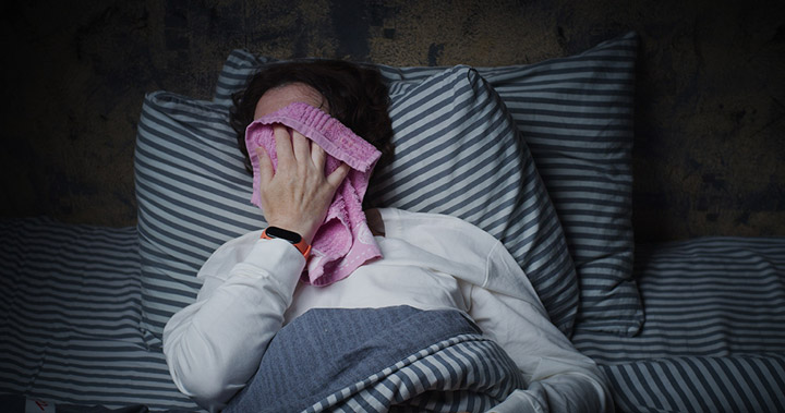 A man wipes his face as he sleeps