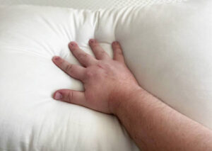 a man pushes into a soft pillow