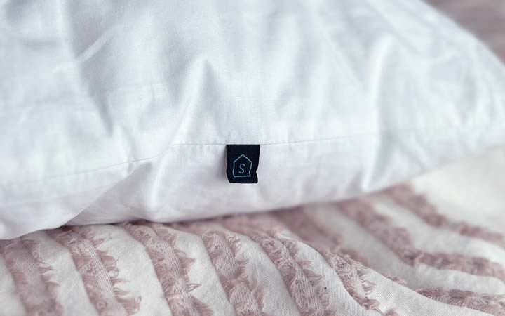 A close up image showing the label for the soft insert of the Luxome Layr pillow.