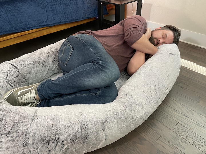 A tall man sleeps on the Plufl