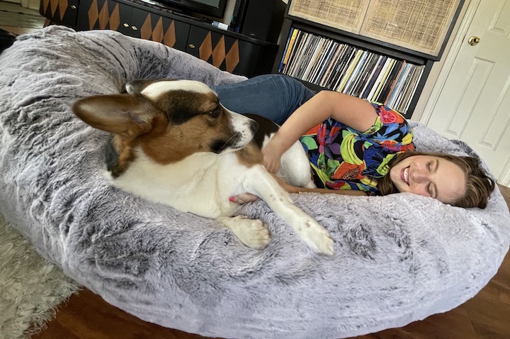 A woman snuggles with her dog in the Plufl