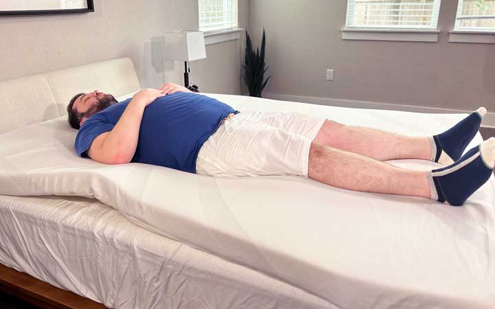 A man rests on his back while on top of the TEMPUR-Adapt mattress topper.