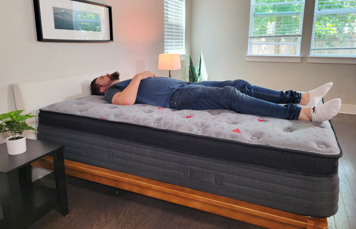 A man lies on his back on the Zoma Boost Hybrid