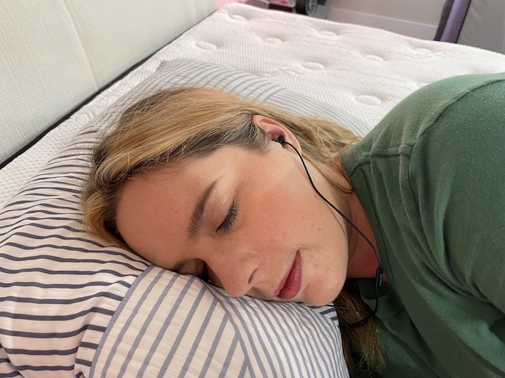 A woman sleeps wearing headphones