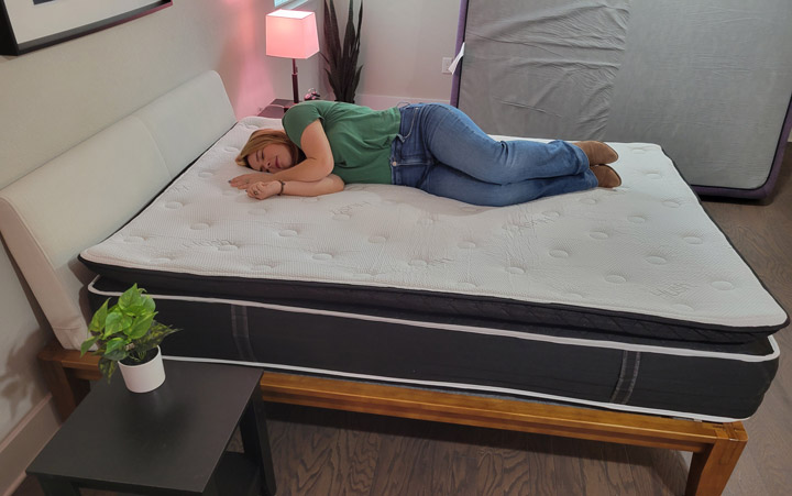 A woman lies on her side on the Hush Arctic Luxe mattress