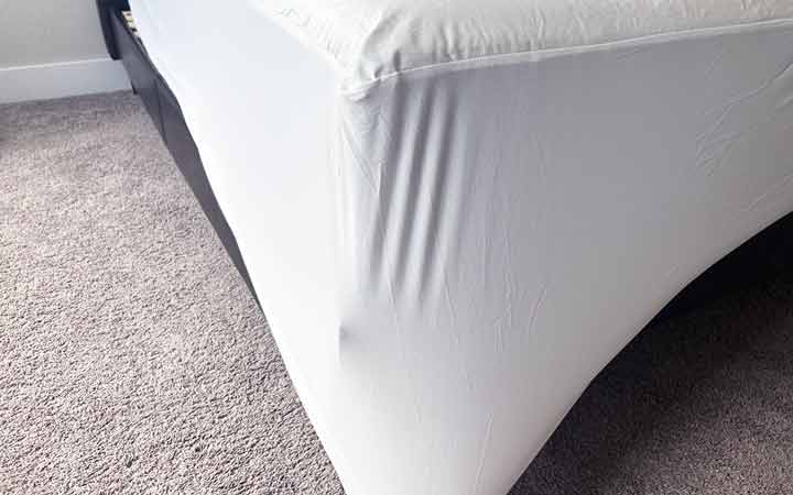 The corner of the Nest Bedding mattress protector pulled tight.