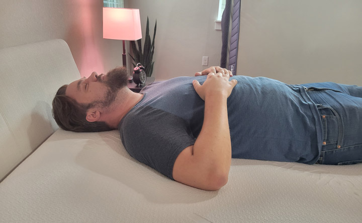 A man sleeps on his back on the Polysleep Origin