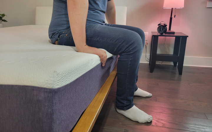 A man sits near the edge of the Polysleep Origin mattress