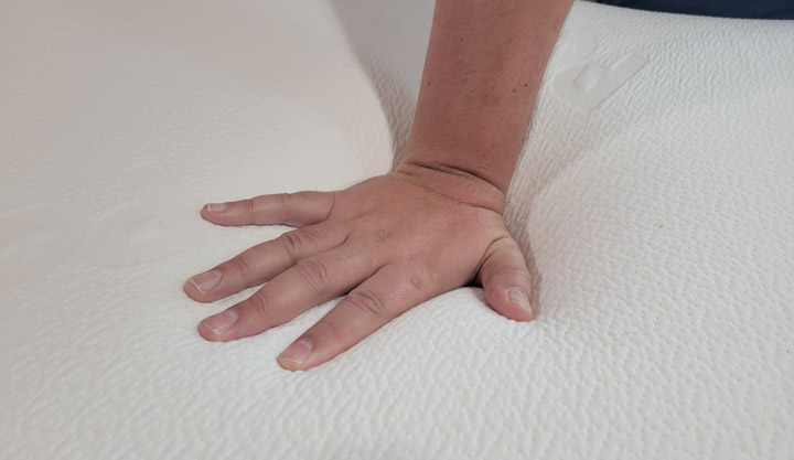 A man presses his hand into the Polysleep Origin mattress