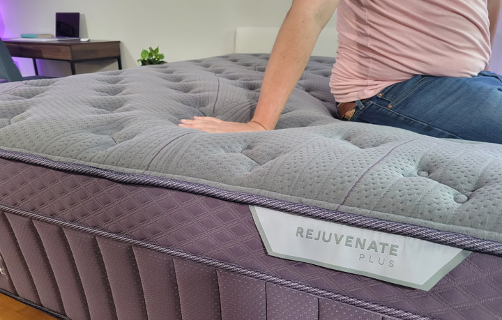 A close shot of a man pressing his hand into the pillow top of the Purple Rejuvenate