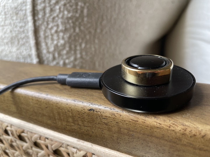 an Oura ring sits on its charging dock
