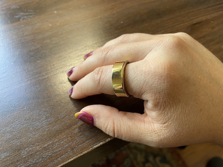a woman wears an Oura ring on her finger