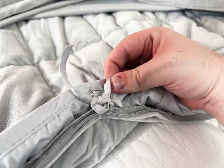 A close up image of the knots connecting the outer cover of the Puffy weighted blanket to the insert.