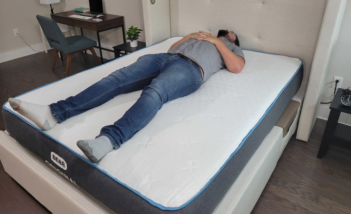 A man sleeps on his back on the Bear Original mattress