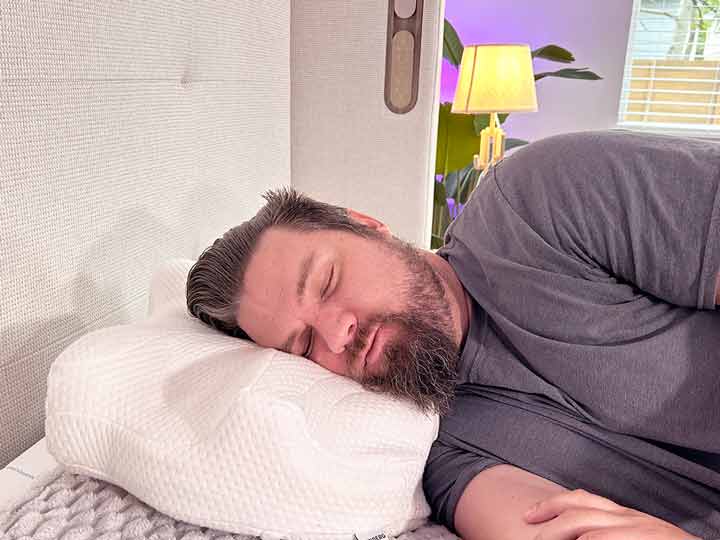 A man sleeps on his side using the Lundberg CPAP machine.