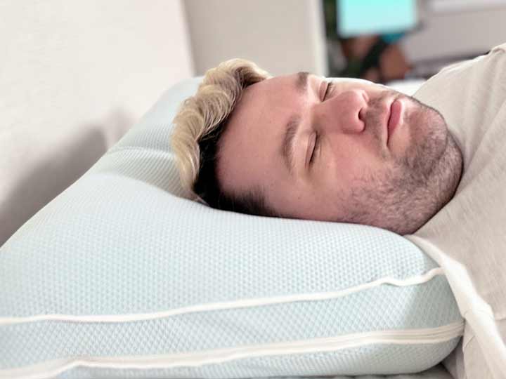 An image of a man sleeping on his back while resting on the TEMPUR-Cloud Cooling Pro pillow.