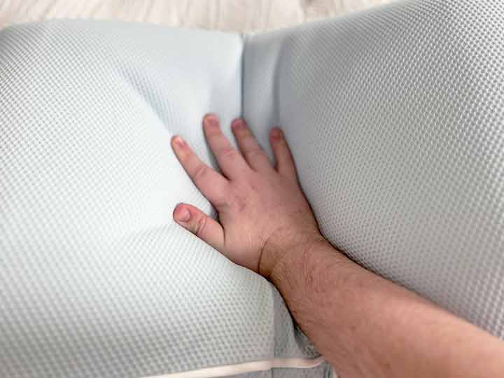 An image of a hand pressing hard into the TEMPUR-Cloud Cooling Pro pillow to show its firmness.
