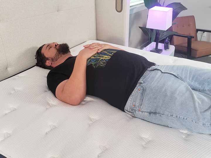 An image of a man sleeping on his back while resting on top of the Titan Plus Luxe