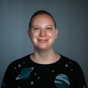 Melanie wearing an outer space-themed sweater and smiling.