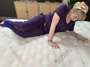 A woman pushes herself up change sleeping positions on the Saatva Classic