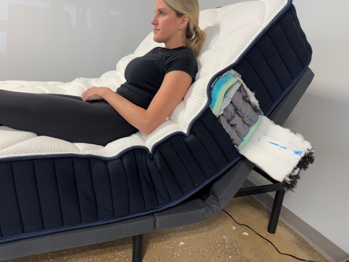 A person sitting up on a DreamCloud Classic Hybrid