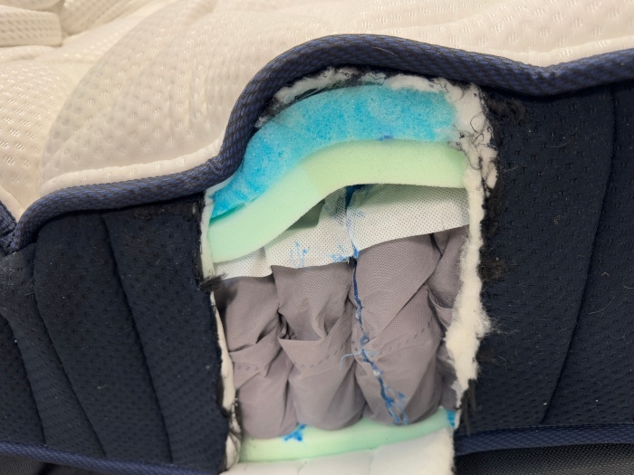 A DreamCloud Classic Hybrid Mattress is cut open to show the layers that make up it's internal construction.