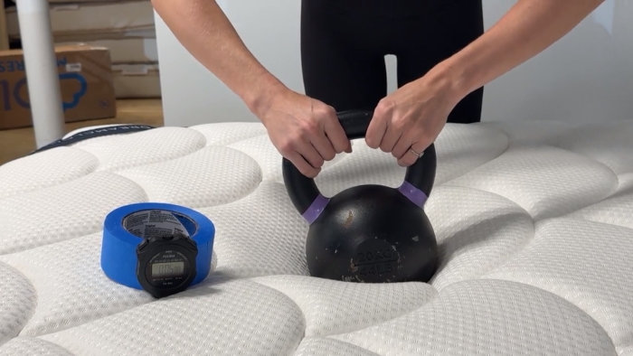 Hands on a kettlebell on a DreamCloud Classic Hybrid