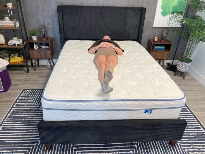 A person lays on their back on the DLX Premier Hybrid