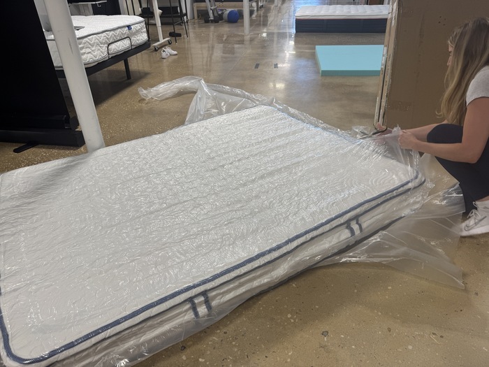 a women is cutting open the sealed DLX Premier Hybrid