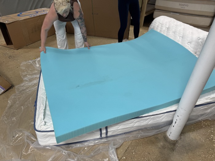 a women positions the top layer of the DLX Premier Hybrid