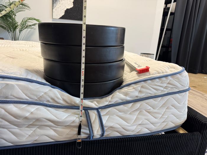a person measures the sinkage on the DLX Premier Hybrid with 4 weights