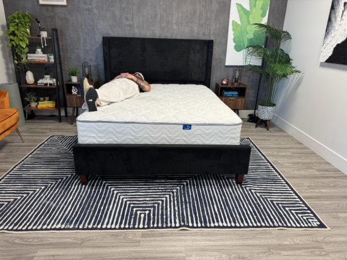 A woman lying on her back on the DLX Classic Two-Sided Mattress