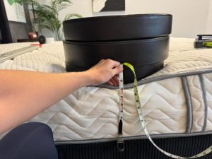 Measuring sinkage at the edge of the DLX Classic Two-Sided Mattress with 3 weight plates stacked on top of the side