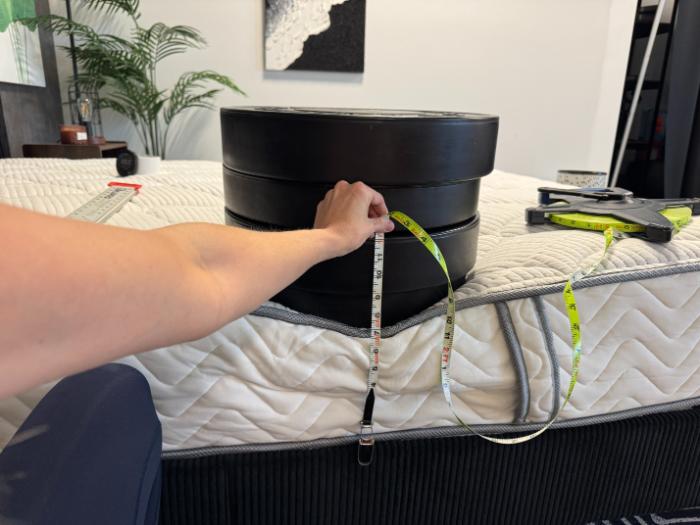 Measuring sinkage at the edge of the DLX Classic Two-Sided Mattress with 3 weight plates stacked on top of the side
