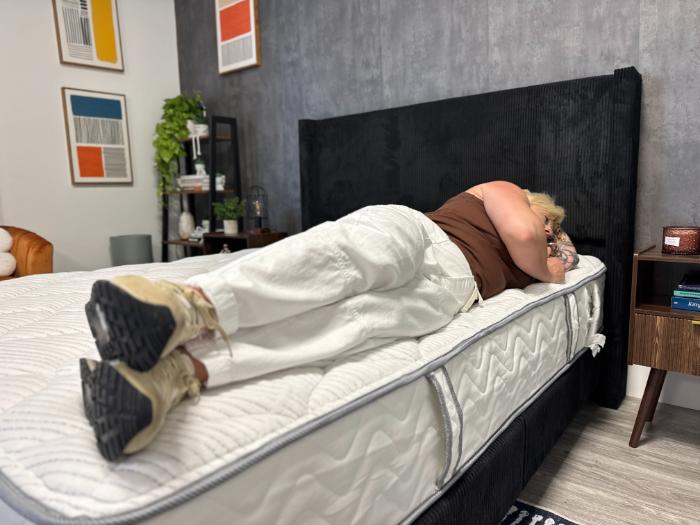 Sosha lying on her side near the very edge of the DLX Classic Two-Sided Mattress