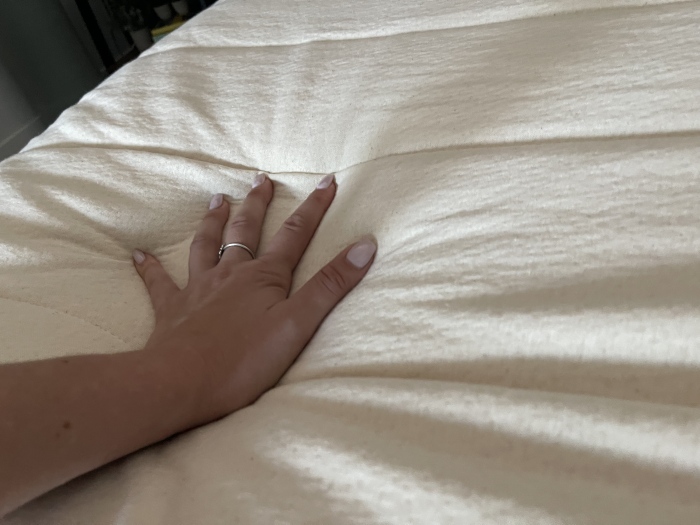 Our tester feeling a Birch Plush Organic Mattress Topper