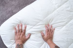 Our tester feeling the Brooklinen Down Alternative Mattress Topper