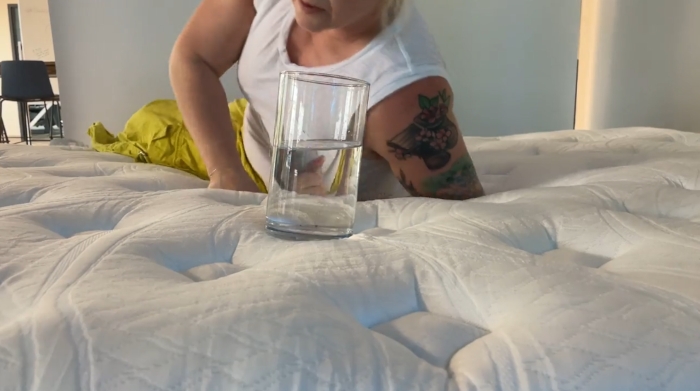 Sosha performs a ripple test on the Wolf Mattress using a glass of water.