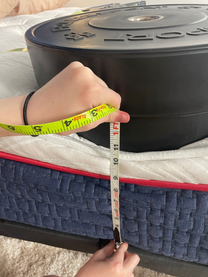 Measuring 2 huge weight plates on the edge of a Wolf Mattress.