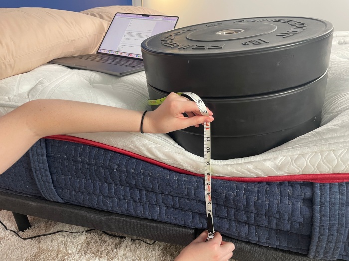 Measuring 3 huge weight plates on the edge of a Wolf Mattress.