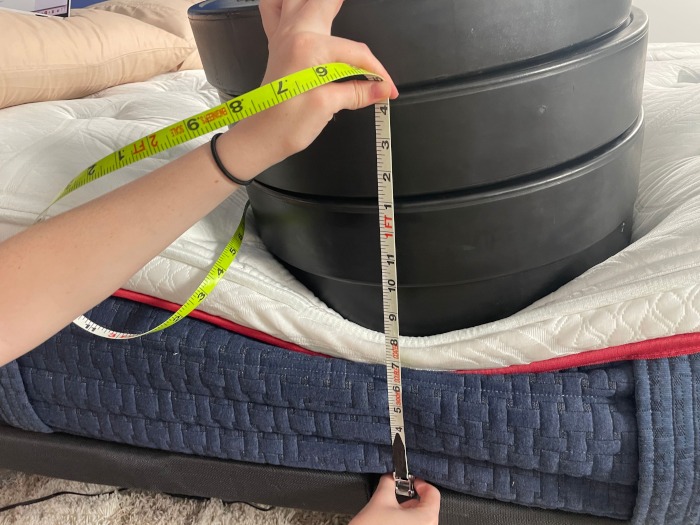Measuring 4 huge weight plates on the edge of a Wolf Mattress.