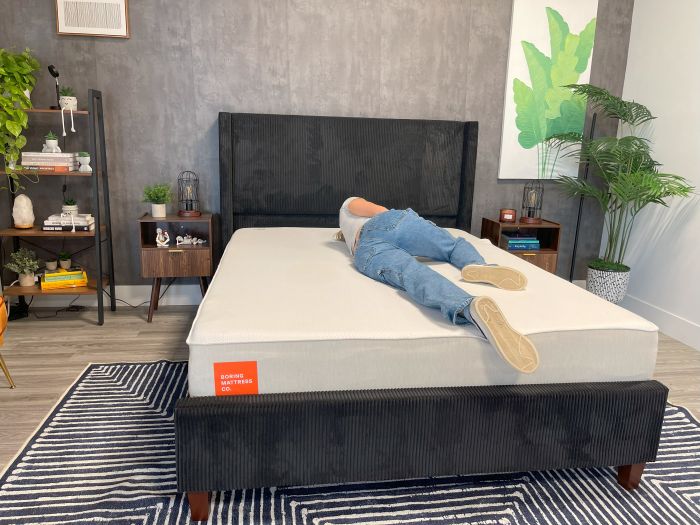 A woman sleeps on her side on the Boring AF mattress