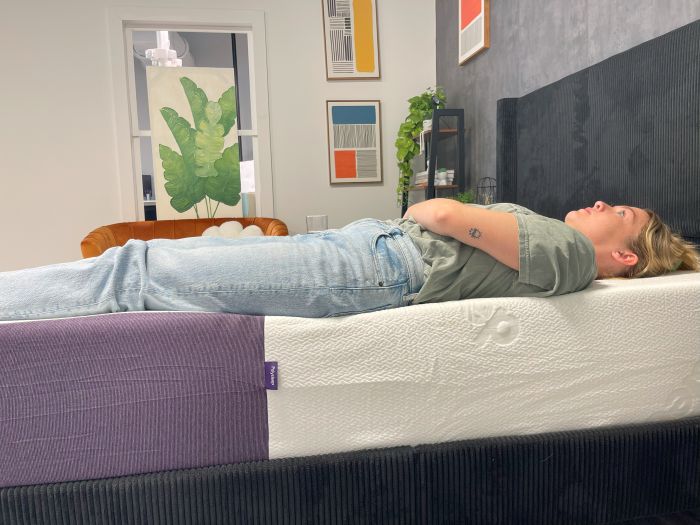 A woman lays on her back on the Polysleep Luna mattress