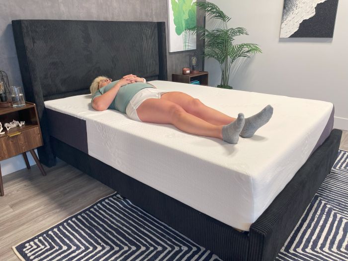 A woman lays on her back on the Polysleep Luna mattress