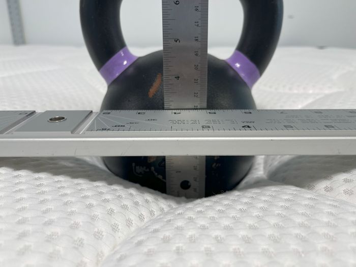 A kettlebell is used to measure sinkage on the DreamCloud Memory Foam mattress